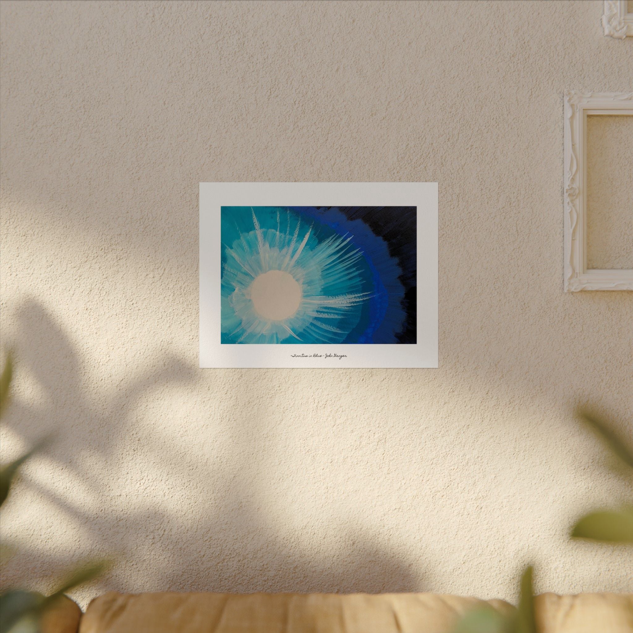 Framed artwork of a blue and white abstract design on a beige wall.