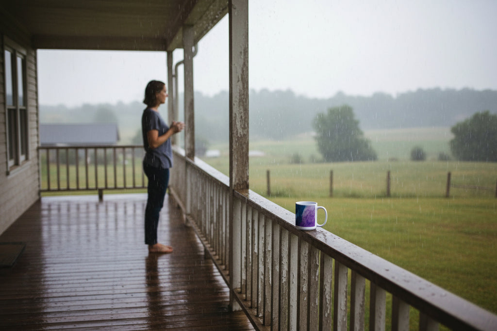 White mug with a purple and blue abstract design on a white background. "Storms of Torment"